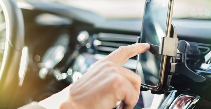 Close up of a man using smart phone while driving